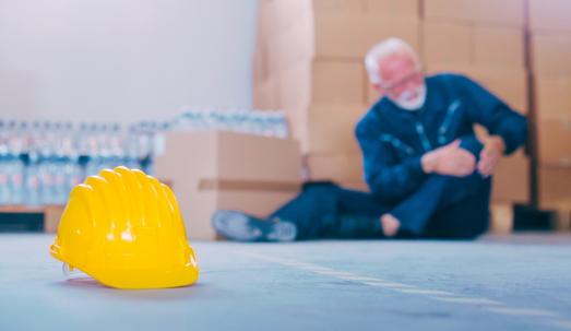 Warehouse worker sitting on the floor after an accident