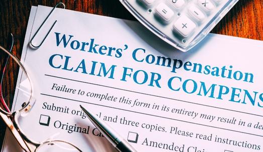 Workers’ Compensation form with pen and glasses