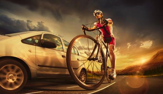 Scenic shot of a cyclist with a car passing through his side