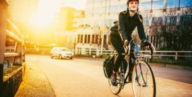 A smiling young woman commuting in an urban city environment on her street