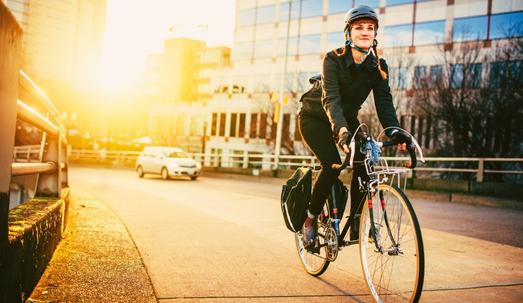 A smiling young woman commuting in an urban city environment on her street