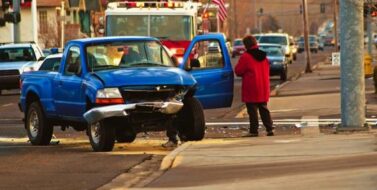 Truck up on a curb with smashed hood and bumper