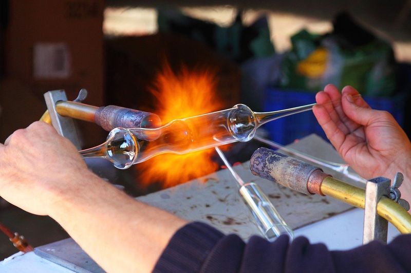 A worker is creating a glass in fire