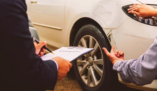 Car insurance policy holder files a claim to insurance agent on his damaged car.