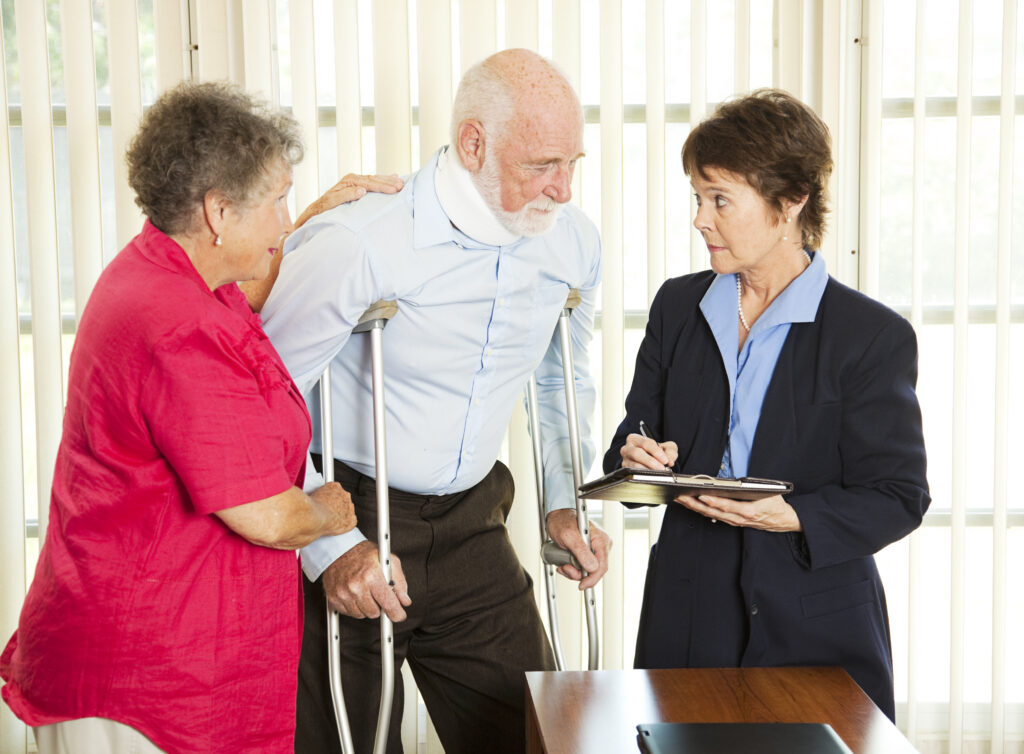 an elderly woman assisting an elderly man in neck brace standing on crutches talking to a lawyer