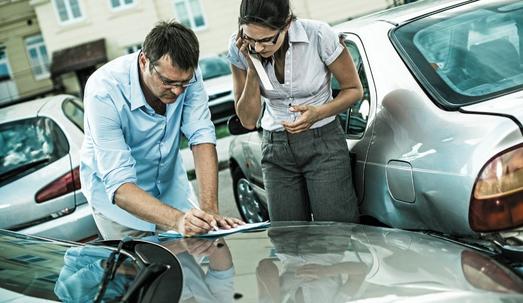 Drivers fill out an accident statement report after having a parking lot accident.