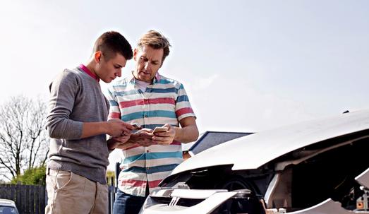 One young motorist swapping insurance details with another mature motorist after a traffic collision.