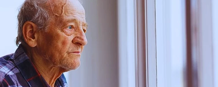 Portrait of Elderly man looking out window. warning signs of elder abuse