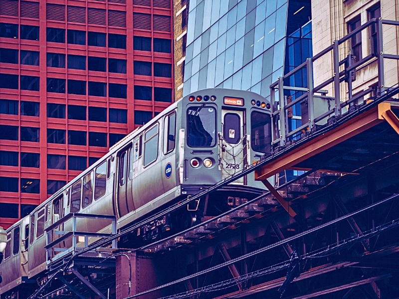 An industrial view of an elevated subway train in Chicago during the daytime.