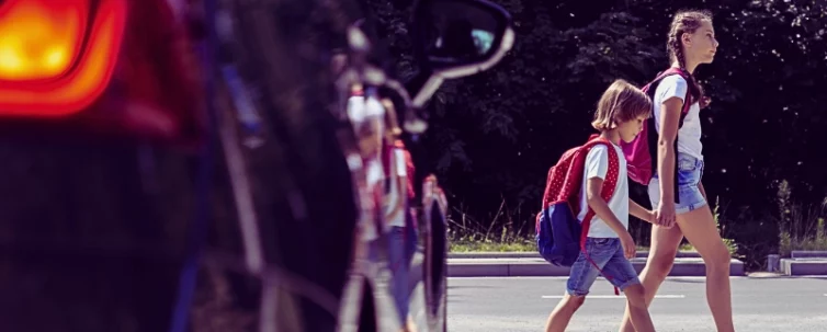 Children next to a car walking through pedestrian crossing to the school. Car Accidents Spike Near Chicago Public Schools