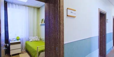 A hallway with several doors on the right side, each with a room number sign.