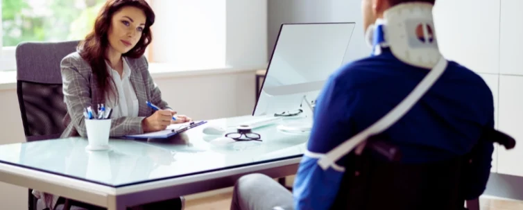 a man in a wheelchair with a neck brace and an arm sling, indicating he has sustained injuries. Uber & Lyft Laws