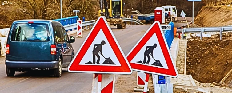 A road construction site with two traffic signs indicating roadwork ahead. Car Accidents in Chicago Construction Zones