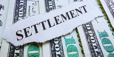 The word "SETTLEMENT" printed on a torn piece of paper placed over several U.S. hundred-dollar bills. Low Settlement Offers