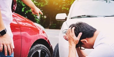 Man holding head in despair after car collision. if the at-fault driver's insurance doesn't cover your injuries