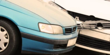 White crash damaged after a left turn accident with a blue car