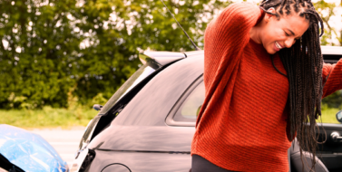 Female Passenger with orange sweater grabbing her injured neck as she exits a damaged car